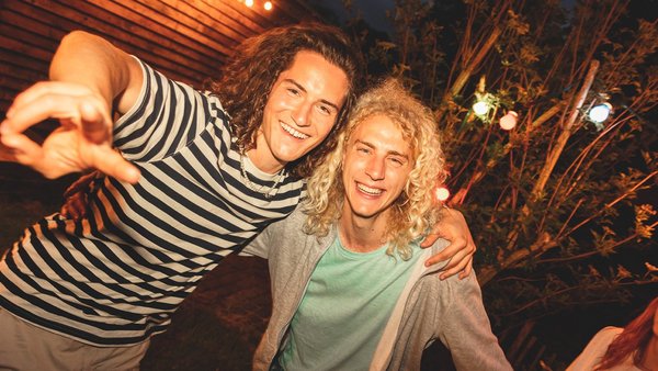 Δύο νεαροί άντρες χαμογελούν στην κάμερα